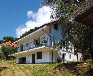 a white house with a balcony on a hill at B&B L'Intrigante in Seborga