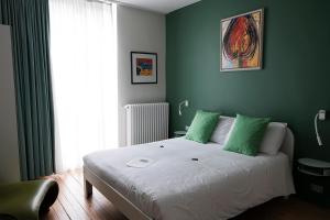 ein Schlafzimmer mit einem großen Bett mit grünen Wänden in der Unterkunft Villa Les Paquerettes in Ostende