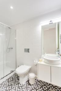 uma casa de banho branca com um lavatório e um WC em DA'HOME - Rola Art Work Studio no Porto