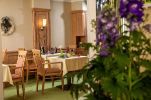 a dining room with a table and chairs and purple flowers at Gästehaus am Markt - Leisnig in Leisnig