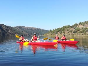 a group of people in red kayaks on the water at Refúgio do Douro Guest House in Bemposta