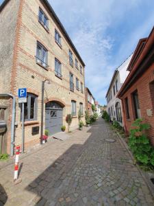 エッカーンフェルデにあるÜber dem Kattsundの煉瓦造りの建物と駐車計のある空き通り