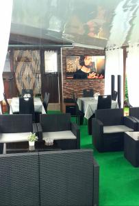 Opanets的住宿－Guest Rooms Simona，一间设有绿色地板和桌椅的餐厅