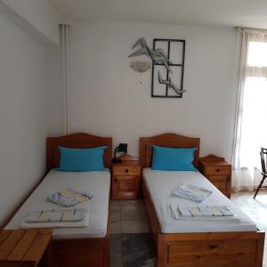 two beds in a room with blue pillows at Slantse in Sozopol +105 photos