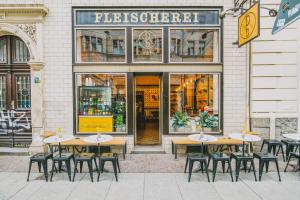a group of tables and chairs in front of a store at theleaf - design apartment & café in Leipzig
