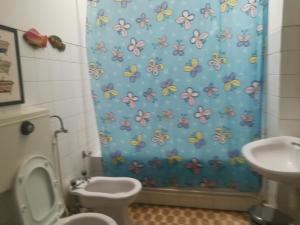 a bathroom with a shower curtain with a toilet and a sink at Refúgio do Douro Guest House in Bemposta