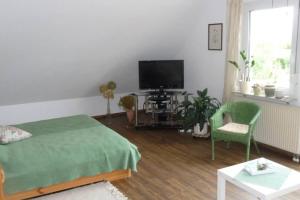 sypialnia z łóżkiem, telewizorem i krzesłem w obiekcie Ferienwohnung Regina w mieście Staufen im Breisgau