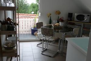 uma cozinha com mesa e cadeiras e uma varanda em Ferienwohnung Regina em Staufen