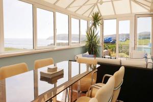 a living room with a glass table and chairs at BODNANT-4 Bed-VIEWS VIEWS VIEWS-ABERDARON in Aberdaron