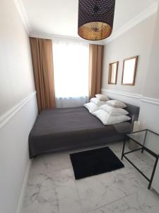 a bedroom with a bed with a large window at Apartament Alicja in Sztutowo