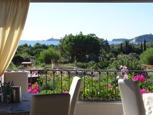 a balcony with chairs and a view of a garden at Hotel Mariposas in Villasimius
