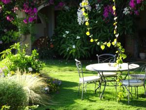 a table and chairs in a yard with flowers at Hotel Mariposas in Villasimius