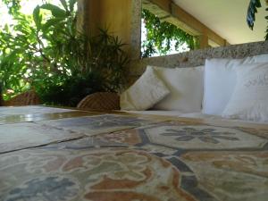 a bed in a room with a rug on a table at Hotel Mariposas in Villasimius