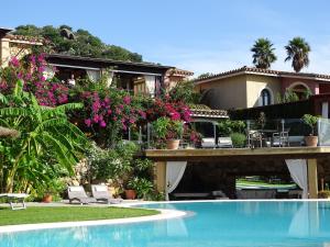 a house with a swimming pool in front of it at Hotel Mariposas in Villasimius