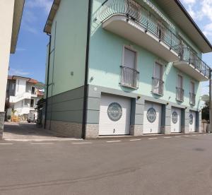 un edificio con tres puertas de garaje en una calle en Gruppo Luxe Domus Vigevano, en Vigevano