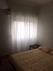 a bedroom with a bed and a white curtain at 66 Peniche in Peniche