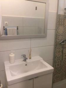 een badkamer met een witte wastafel en een spiegel bij 66 Peniche in Peniche