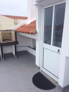 a balcony with a door and a chair on a building at 66 Peniche in Peniche