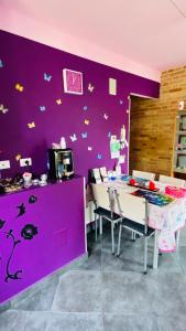 una sala da pranzo con pareti viola e tavolo e sedie di B&B Dolce Sogno a SantʼElpidio a Mare