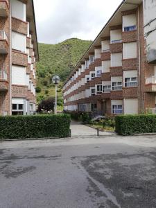 um parque de estacionamento vazio em frente a um edifício de apartamentos em Apartamento Peñalabra em Potes