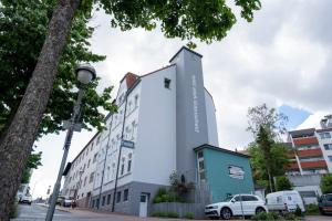 a building on a street with a tree at Hotel Stadt Lüdenscheid in Lüdenscheid