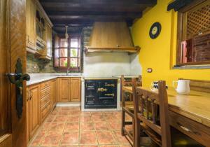 a kitchen with yellow walls and a stove at Casa Bouza in Becerreá