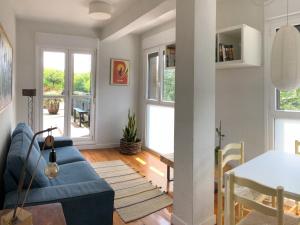a living room with a blue couch and a table at Zarautz Hostel in Zarautz