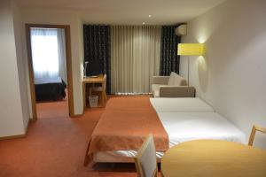 a hotel room with two beds and a living room at Paredes Hotel Apartamento in Paredes +47 photos