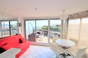 a living room with a red couch and a table at Nice apartment last floor with terrace and clear view on the sea in Cannes
