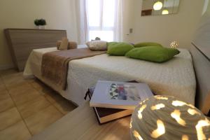 una camera da letto con un letto con cuscini verdi e un tavolo di Casa vacanze Nicole in Salento 5 posti a Otranto