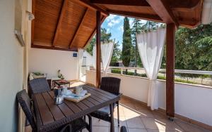 une terrasse couverte avec une table et des chaises en bois sur un balcon dans l'établissement Apartment Katoro, à Umag