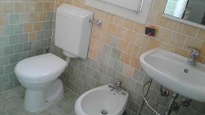 y baño con aseo blanco y lavamanos. en CASA DEI PESCATORI BELLARIA, en Bellaria-Igea Marina