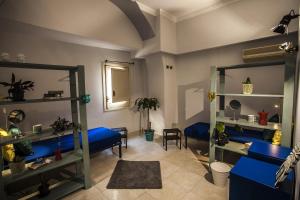 a living room with blue beds and a mirror at Ostello degli Elefanti in Catania