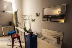 a bathroom with a sink and a mirror and a stool at Ostello degli Elefanti in Catania