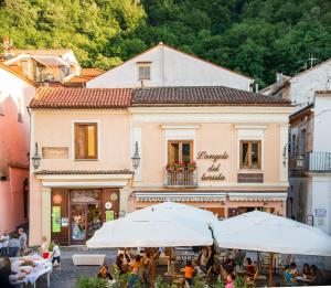 a street with tables and umbrellas in front of a building at La stanza dell'angolo in Maratea