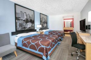 una camera d'albergo con due letti e una scrivania di Super 8 by Wyndham City of Moore a Moore