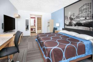a hotel room with a bed and a flat screen tv at Super 8 by Wyndham City of Moore in Moore