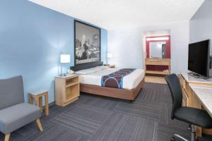 a hotel room with a bed and a flat screen tv at Super 8 by Wyndham City of Moore in Moore