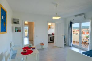 a white living room with a table and chairs at Lyceum Flat in Olbia