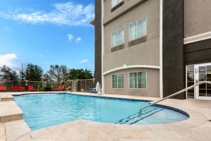 a swimming pool in front of a building at La Quinta by Wyndham Alvin in Alvin