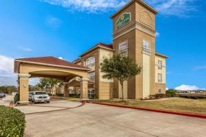 a hotel with a clock tower in a parking lot at La Quinta by Wyndham Angleton in Angleton