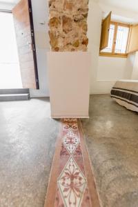 a room with a white wall and a stone wall at El 32 in Lorca