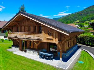 une grande maison en bois avec un toit dans l'établissement Chalet luxe L'HIBISCUS, à Samoëns