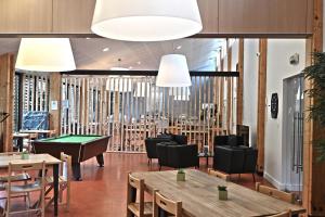 a restaurant with tables and a pool table at Hôtel Le Marintan in Saint-Michel-de-Maurienne