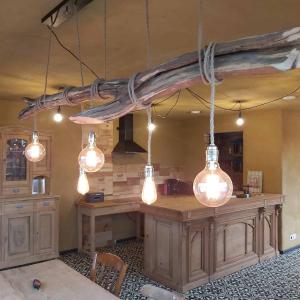 a driftwood beam hanging from a kitchen island with lights at B&B Clogher Farm in Poperinge