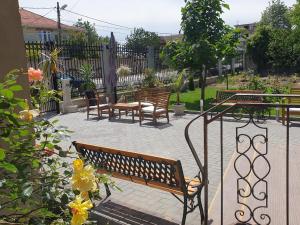 a group of benches and tables in a garden at casa adrian 2 mai in 2 Mai