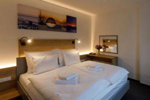 ein Schlafzimmer mit einem weißen Bett mit zwei Handtüchern darauf in der Unterkunft Sporthotel Olympia in Stachy
