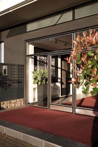 une porte en verre d'un bâtiment avec une plante en pot dans l'établissement SAXX Apartments "Goldberg Karree", à Hagen