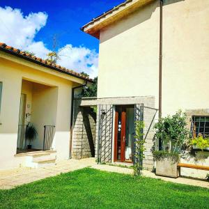 una casa blanca con una puerta roja y un patio en Alloggio Turistico Vigna Clara, en Viterbo