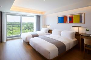 a hotel room with a large bed and a large window at Lahan Select Gyeongju in Gyeongju